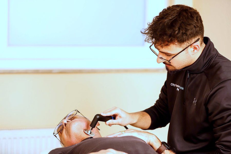 Therapeut behandelt den Kieferbereich eines Patienten