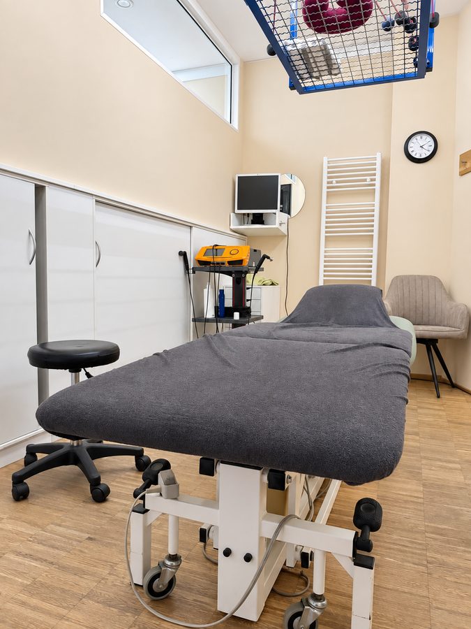 Behandlungsraum mit Therapieliege und Schlingentisch